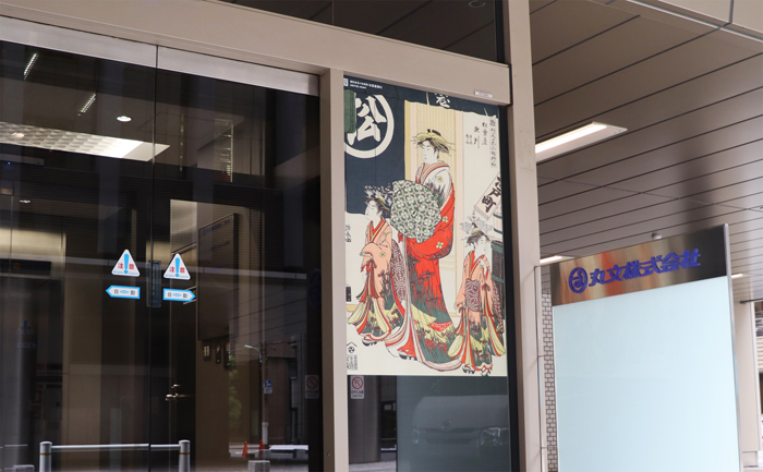 本社 1 階⼊⼝の浮世絵フィルム。「雛形若菜の初模様 松葉屋瀬川」